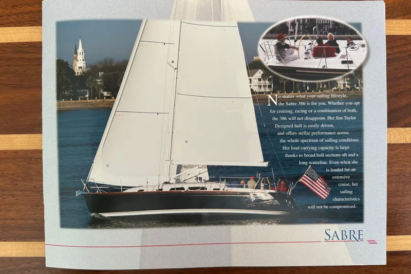 Slide: The Image of Sailing yacht Sabre 386, 2007 model, cruising near a coastal town with American flag. - 170