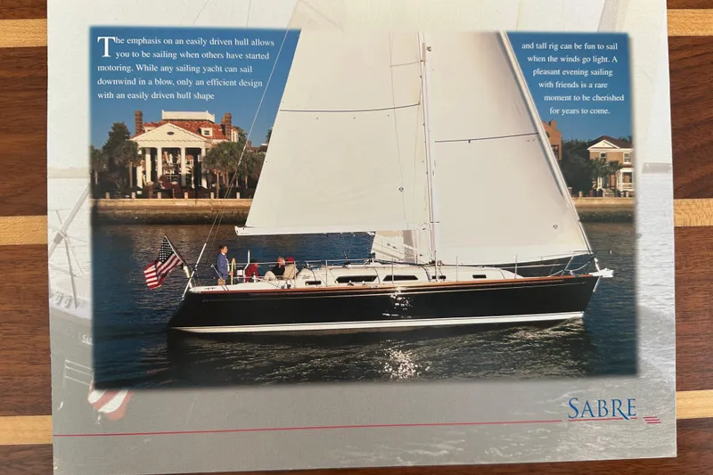 Slide: The Image of Sailing yacht Sabre 386, 2007 model, cruising near waterfront homes with American flag. - 174