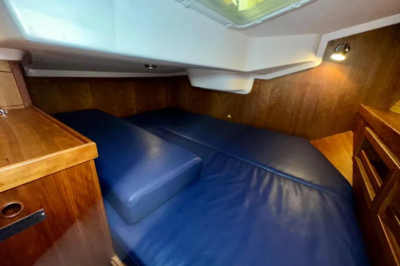 Slide: The Image of Cozy cabin interior of 2007 Sabre 386 sailboat with blue cushions and wood paneling. - 30