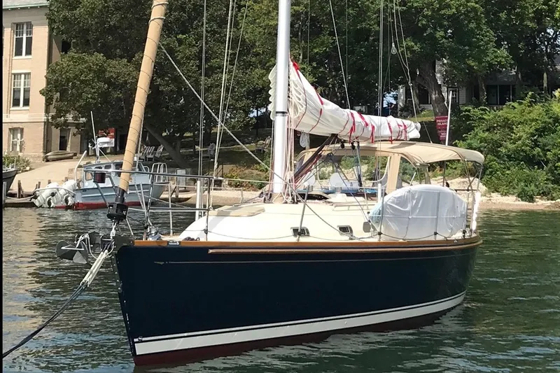 Slide: The Image of Sailboat Sabre 386, 2007 model, docked near a leafy shoreline. - 4