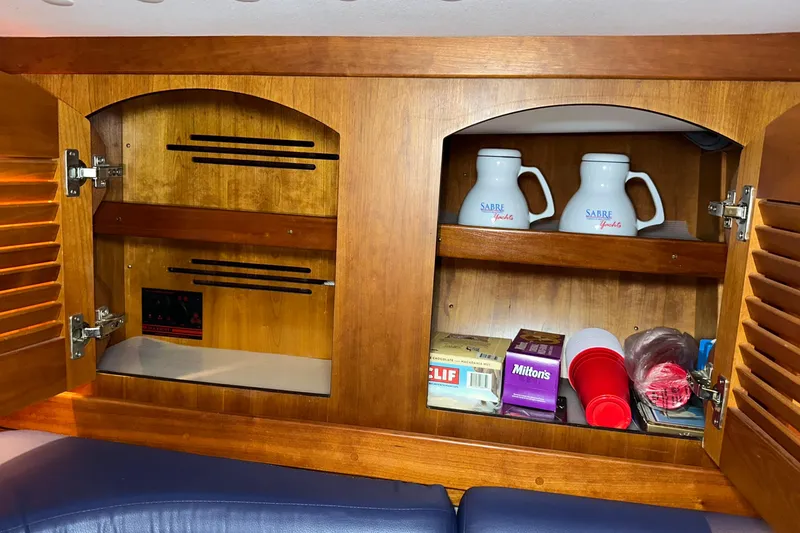 Slide: The Image of Wooden cabinet in a 2007 Sabre 386 yacht, storing mugs and snacks. - 43