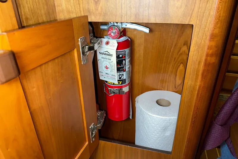 Slide: The Image of Fire extinguisher and paper towel in wooden cabinet on 2007 Sabre 386 boat. - 54