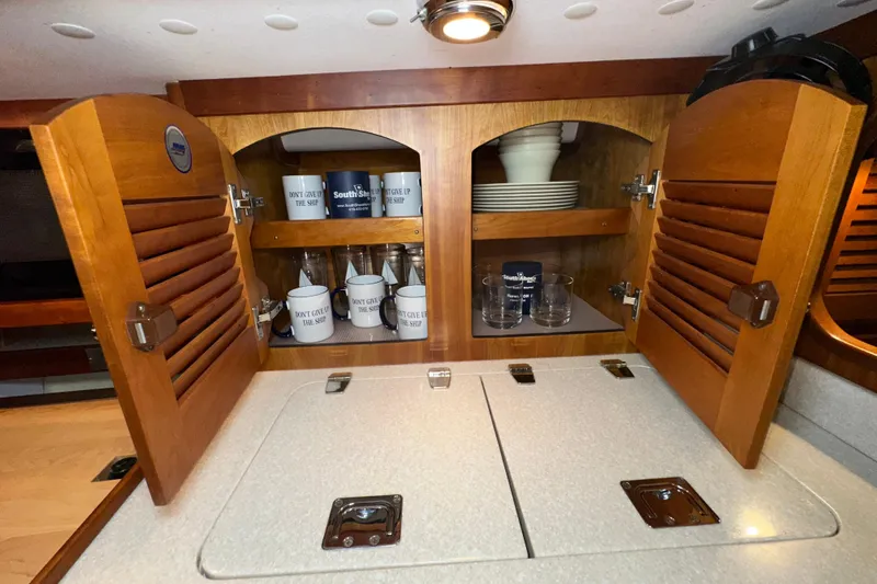 Slide: The Image of Wooden cabinet in 2007 Sabre 386 yacht galley, stocked with mugs and glassware. - 55