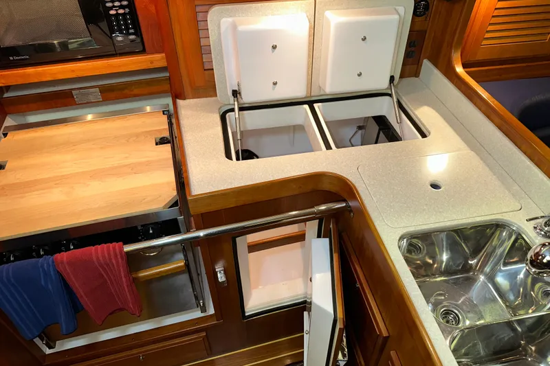 Slide: The Image of Luxurious 2007 Sabre 386 yacht kitchen with wood cabinetry, dual sinks, and modern appliances. - 56