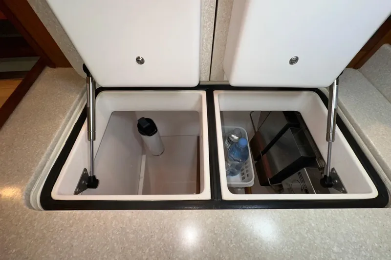 Slide: The Image of Open storage compartments in a 2007 Sabre 386 yacht galley, featuring organized items. - 58