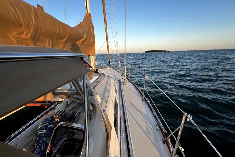 Slide: The Image of Sailing on a 2007 Sabre 386 yacht at sunset, with distant island view. - 9