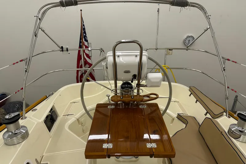 Slide: The Image of 2007 Sabre 386 sailboat cockpit with steering wheel, wooden table, and American flag. - 91