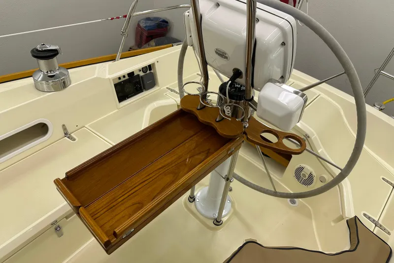 Slide: The Image of 2007 Sabre 386 yacht cockpit with steering wheel and wooden table. - 93