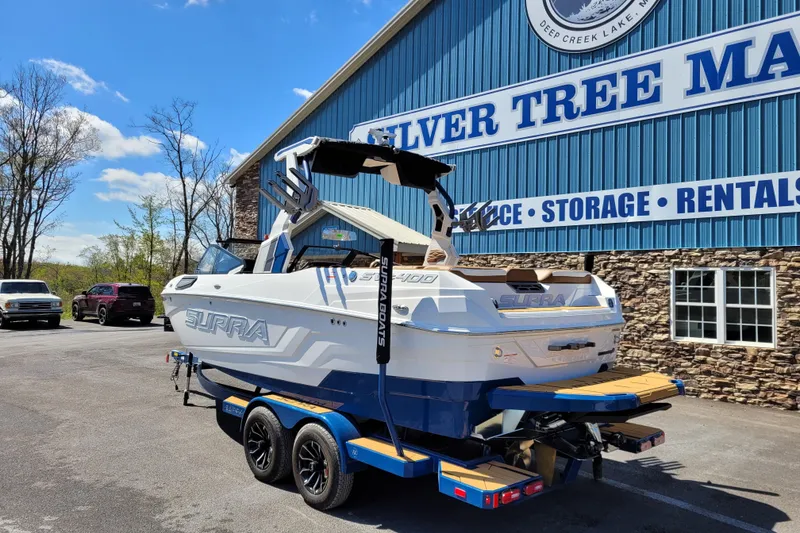 Slide: The Image of 2026 Supra SV 400 boat on trailer at Silver Tree Marine, sunny day. - 2