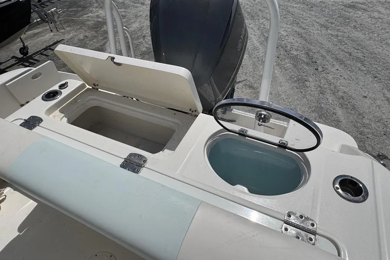 Slide: The Image of 2018 Robalo R242 Center Console with storage compartments and engine view. - 20