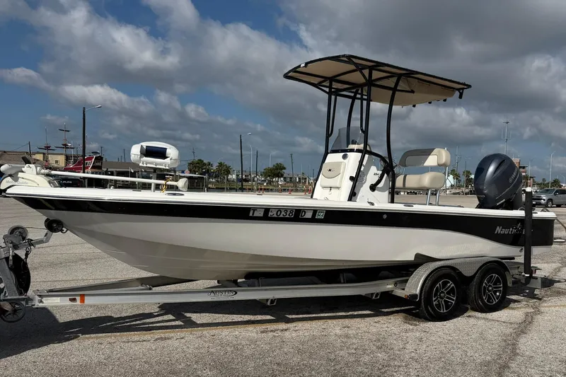 The Image of 2015 NauticStar 224 XTS boat on trailer under cloudy sky. - 0