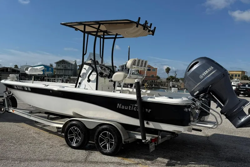 Slide: The Image of 2015 NauticStar 224 XTS boat with Yamaha engine on trailer, dockside view. - 2