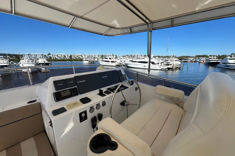 Slide: The Image of 2017 Kadey-Krogen 58EB yacht deck with seating and tables, overlooking marina. - 64