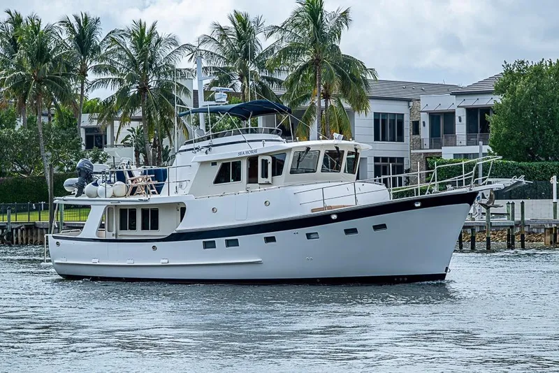 The Image of 2016 Kadey-Krogen 52 yacht cruising near waterfront homes and palm trees. - 0