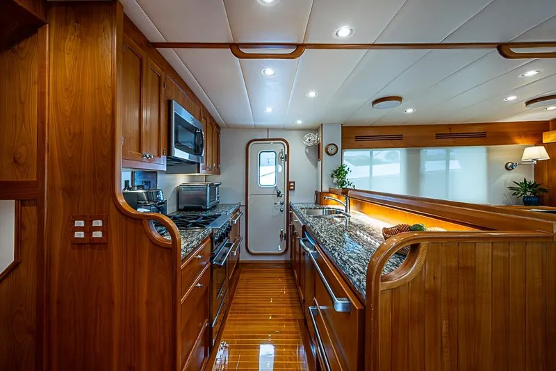 Slide: The Image of Luxurious 2016 Kadey-Krogen 52 yacht kitchen with wood cabinetry and granite countertops. - 12
