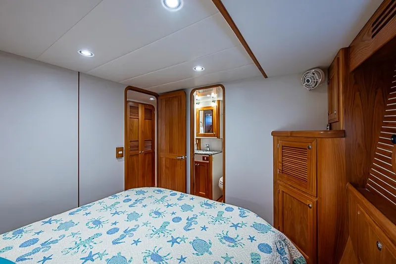 Slide: The Image of Luxurious 2016 Kadey-Krogen 52 yacht bedroom with wooden cabinetry and nautical-themed bedding. - 34