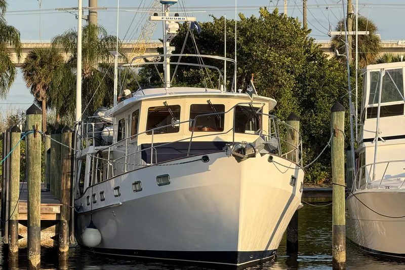 Slide: The Image of 2008 Kadey-Krogen 48 North Sea yacht docked at marina with lush greenery. - 2