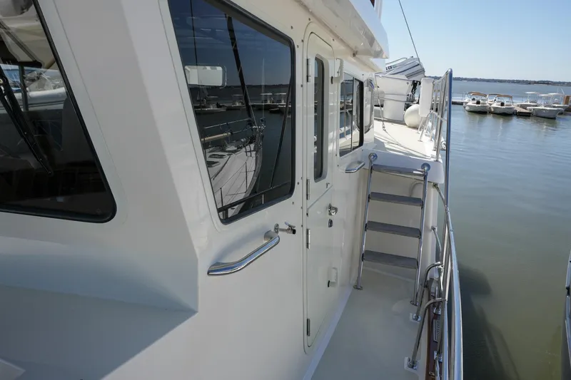 Slide: The Image of 2008 Kadey-Krogen 48 North Sea yacht docked, showcasing side deck and ladder. - 52