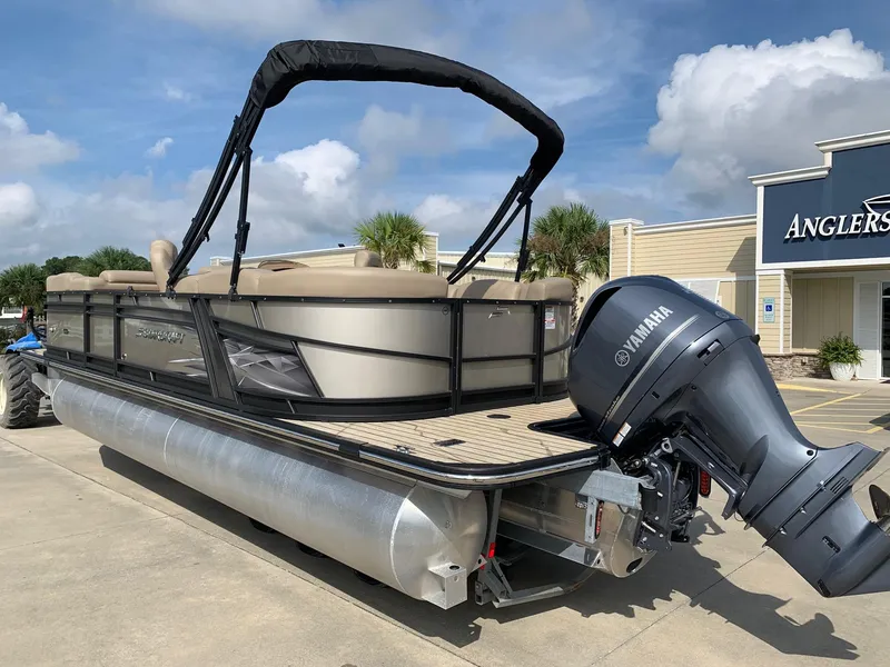 Slide: The Image of 2021 Starcraft SLS 3 pontoon boat with Yamaha motor, parked outside a store. - 2