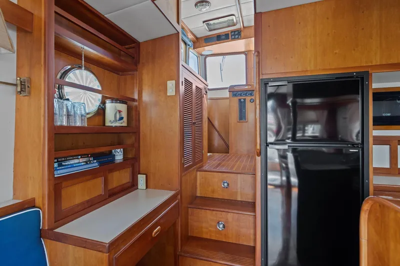 Slide: The Image of Interior of 1999 Kadey-Krogen 39 yacht with wooden cabinetry and black refrigerator. - 11
