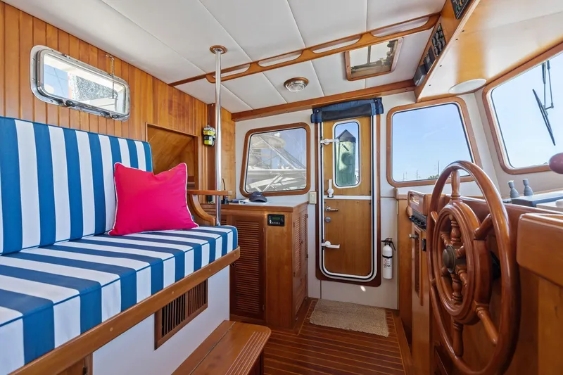 Slide: The Image of Interior of 1999 Kadey-Krogen 39 boat with striped seating and wooden helm. - 12