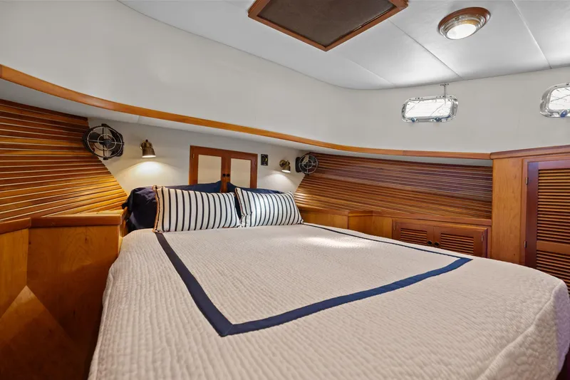 Slide: The Image of Cozy bedroom in 1999 Kadey-Krogen 39 yacht with wood paneling and striped bedding. - 27