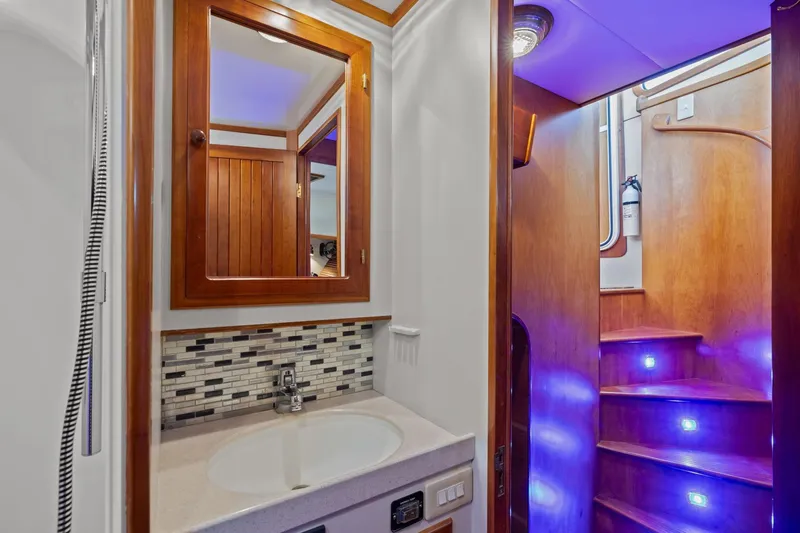 Slide: The Image of Elegant 1999 Kadey-Krogen 39 yacht interior with wooden cabinetry and illuminated staircase. - 29