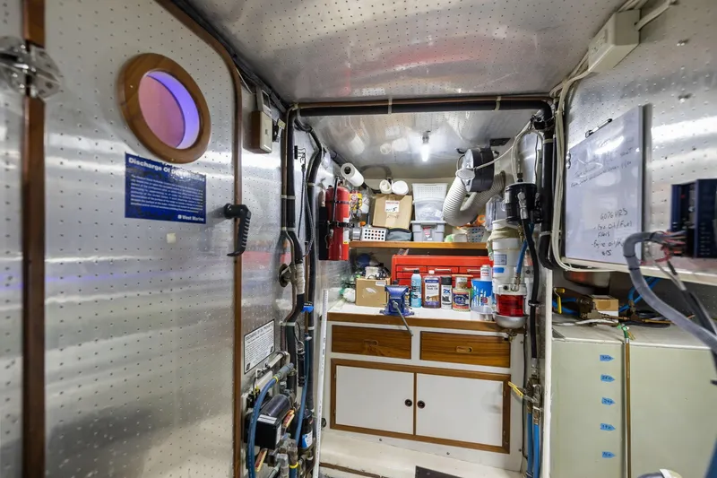 Slide: The Image of Engine room of a 1999 Kadey-Krogen 39 boat, featuring tools and equipment. - 32
