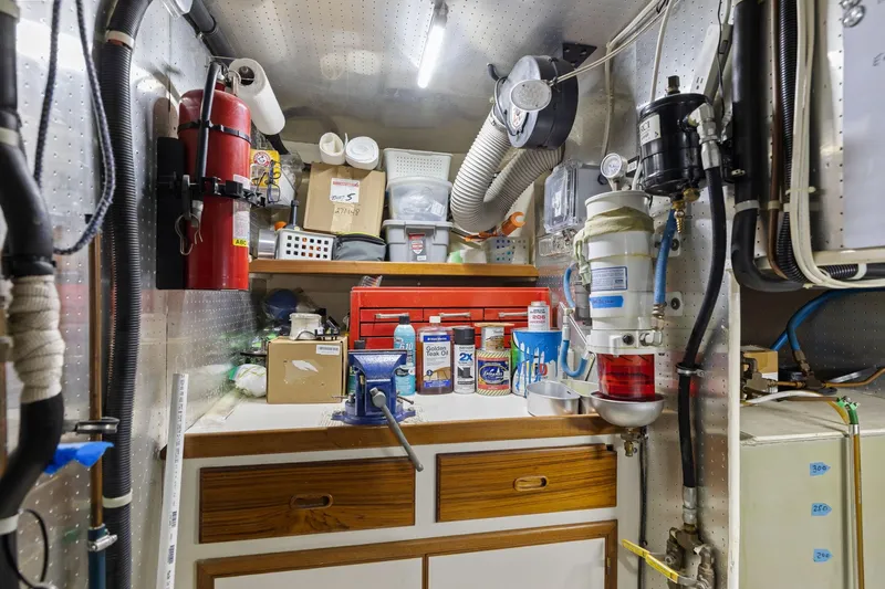 Slide: The Image of Engine room of a 1999 Kadey-Krogen 39 boat, featuring tools and equipment. - 35
