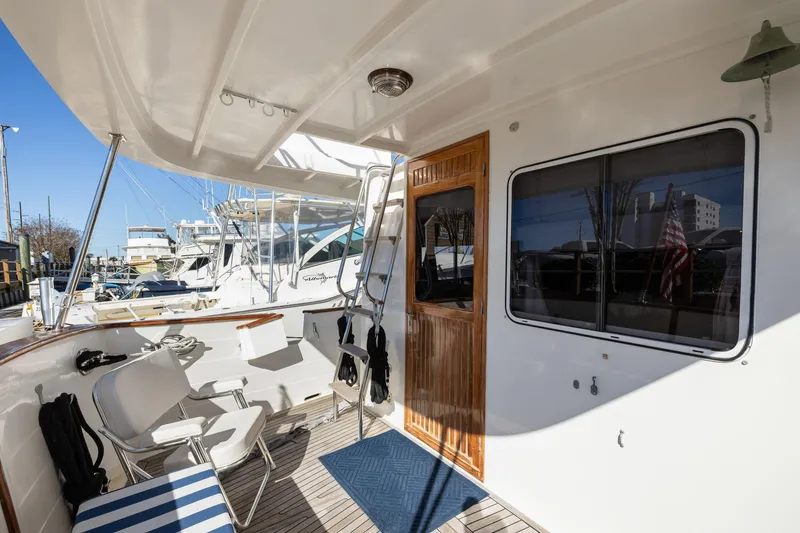 Slide: The Image of 1999 Kadey-Krogen 39 yacht deck with seating, wooden door, and window. - 39