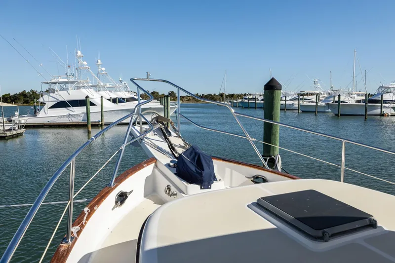 Slide: The Image of Bow view of 1999 Kadey-Krogen 39 yacht docked in a marina under clear blue skies. - 40