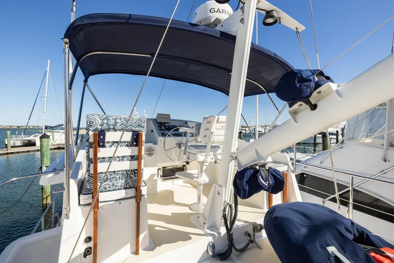 Slide: The Image of 1999 Kadey-Krogen 39 yacht cockpit with blue canopy and steering wheel, docked at marina. - 42