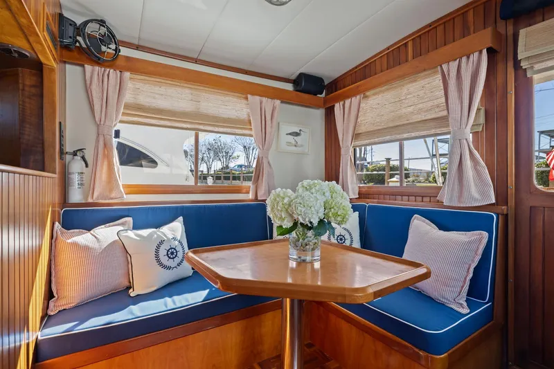 Slide: The Image of Cozy interior of 1999 Kadey-Krogen 39 yacht with blue seating and floral centerpiece. - 5