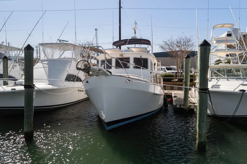 Slide: The Image of 1999 Kadey-Krogen 39 yacht docked between boats in marina. - 52