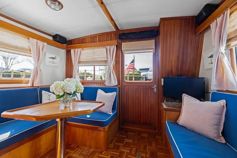 Slide: The Image of Interior of 1999 Kadey-Krogen 39 yacht with blue seating, wooden table, and decorative flowers. - 6
