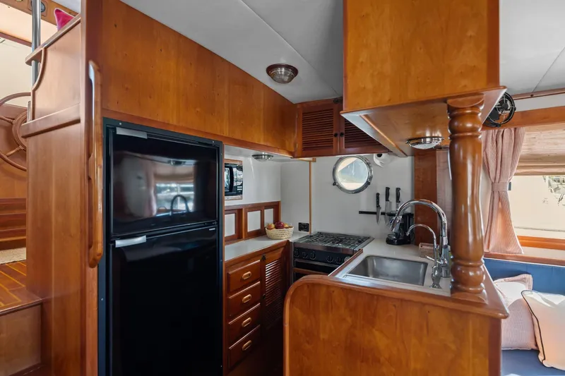 Slide: The Image of Cozy 1999 Kadey-Krogen 39 yacht kitchen with wood cabinetry, sink, stove, and refrigerator. - 9