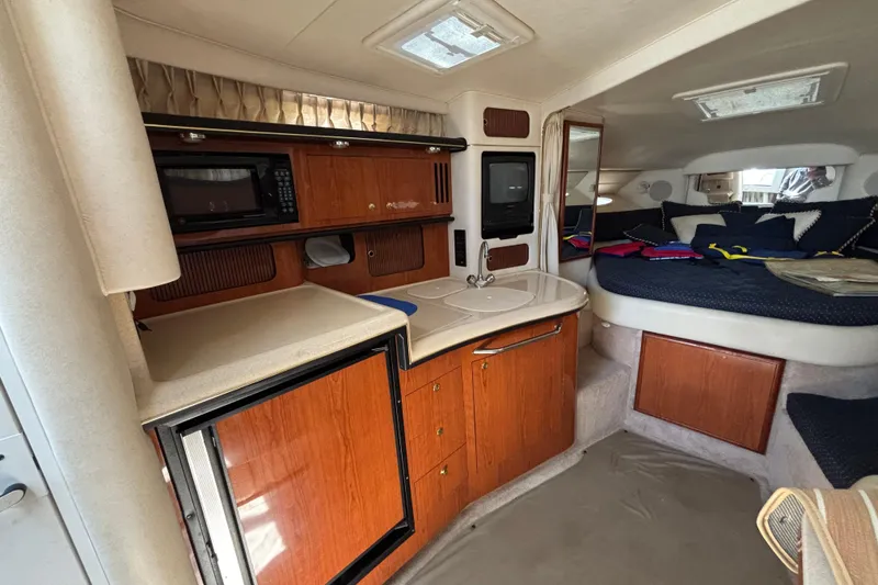 Slide: The Image of 2000 Sea Ray 340 Sundancer cabin interior with kitchenette and cozy sleeping area. - 14