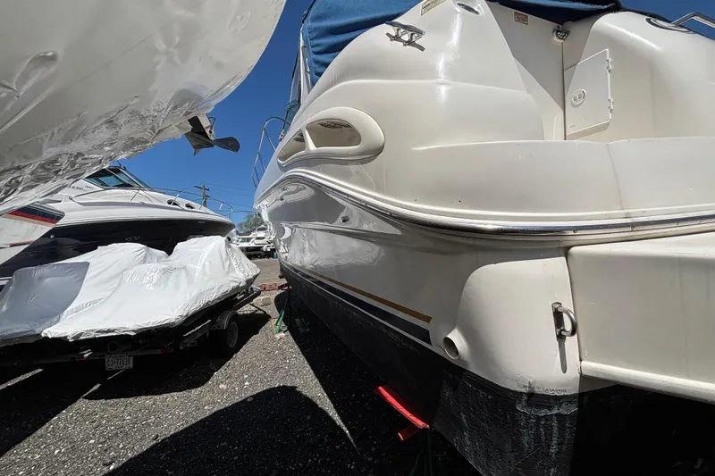 Slide: The Image of 2000 Sea Ray 340 Sundancer yacht in storage, partially covered, with adjacent boats. - 2