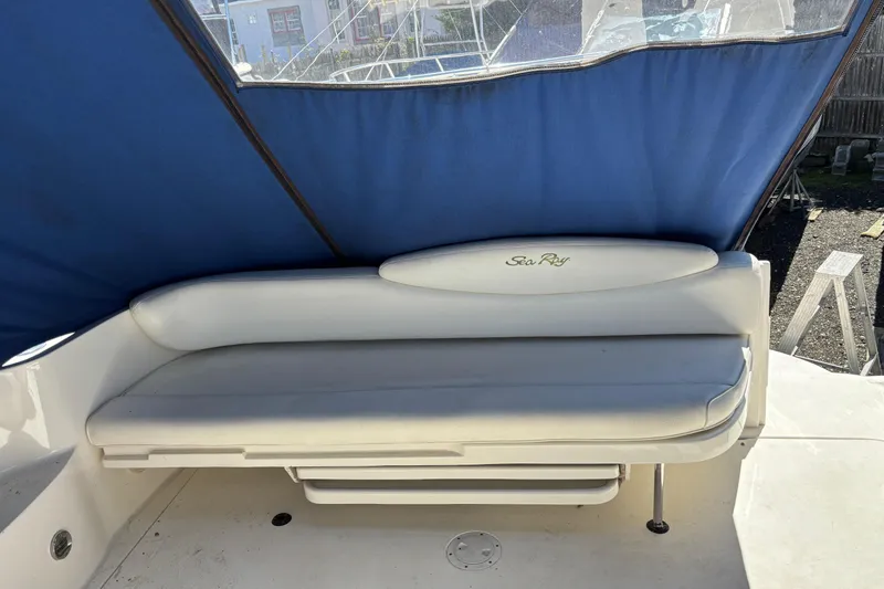 Slide: The Image of 2000 Sea Ray 340 Sundancer boat interior with cushioned seating and blue canopy. - 8