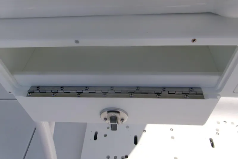 Slide: The Image of 2026 Sportsman Open 252 Center Console storage compartment with stainless steel hinge detail. - 11