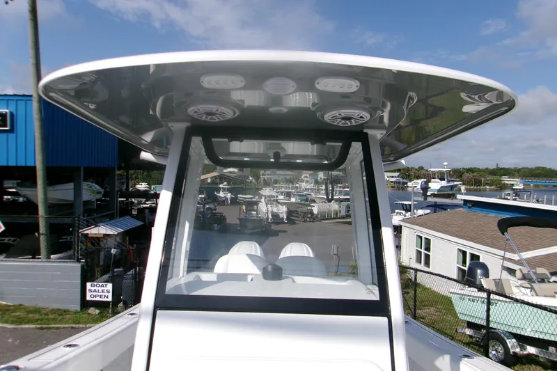 Slide: The Image of 2026 Sportsman Open 252 Center Console boat at a marina, showcasing helm and T-top. - 15
