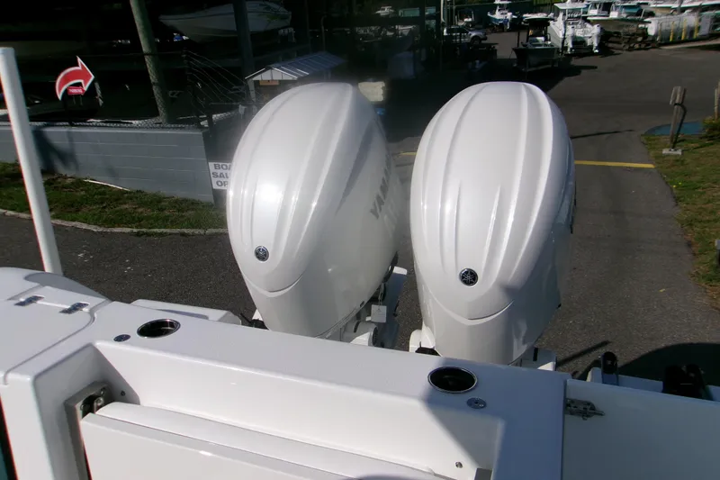 Slide: The Image of 2026 Sportsman Open 252 Center Console with dual outboard engines at a marina. - 8