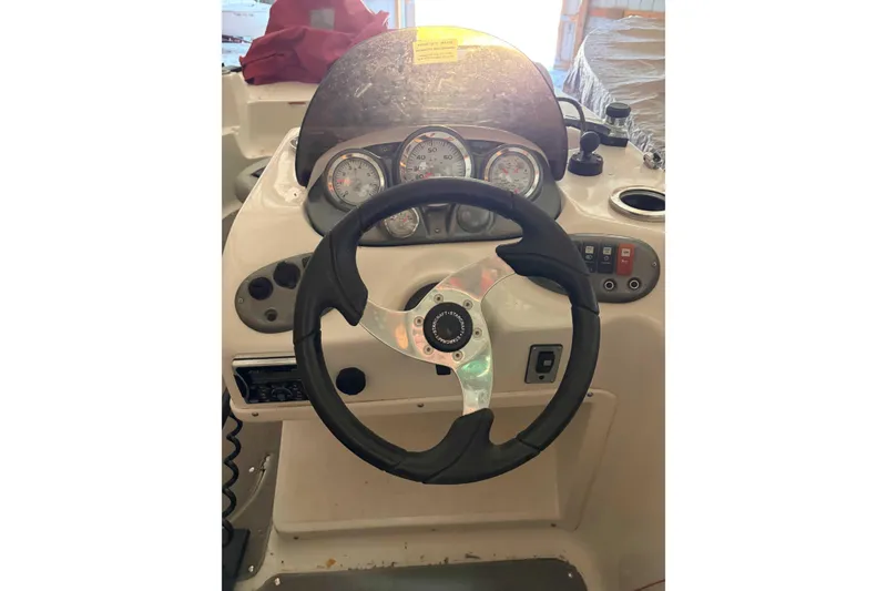 Slide: The Image of Steering console of a 2013 Starcraft 2000 IO Limited boat with gauges and controls. - 2