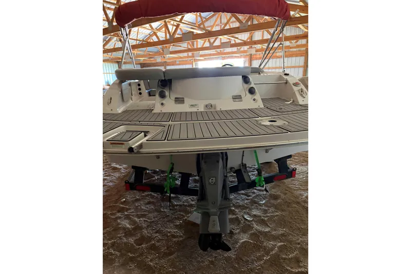 Slide: The Image of 2013 Starcraft 2000 IO Limited boat in storage, rear view with red canopy. - 4