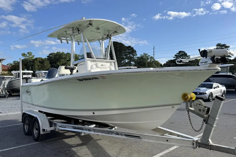 Slide: The Image of 2016 Sea Hunt Ultra 211 boat on trailer, parked outdoors under a clear sky. - 1