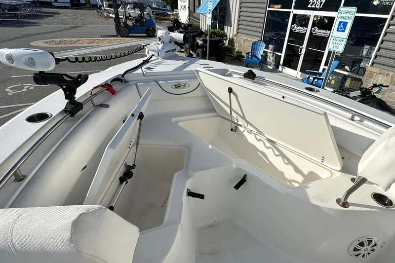 Slide: The Image of 2016 Sea Hunt Ultra 211 boat interior with open storage compartments and fishing rod holders. - 13