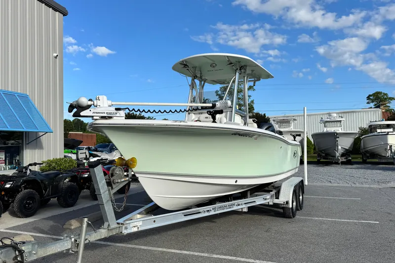 Slide: The Image of 2016 Sea Hunt Ultra 211 boat on trailer, parked outdoors under blue sky. - 2