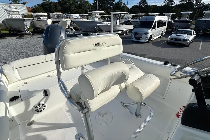 Slide: The Image of 2016 Sea Hunt Ultra 211 boat interior with white seating and steering wheel. - 8