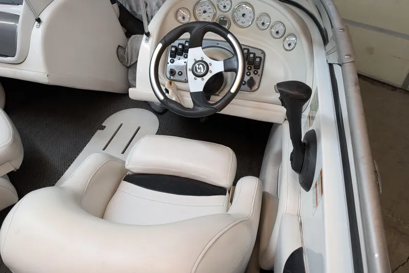Slide: The Image of Interior of a 2005 Sylvan V190 I/O boat featuring steering wheel and dashboard controls. - 4