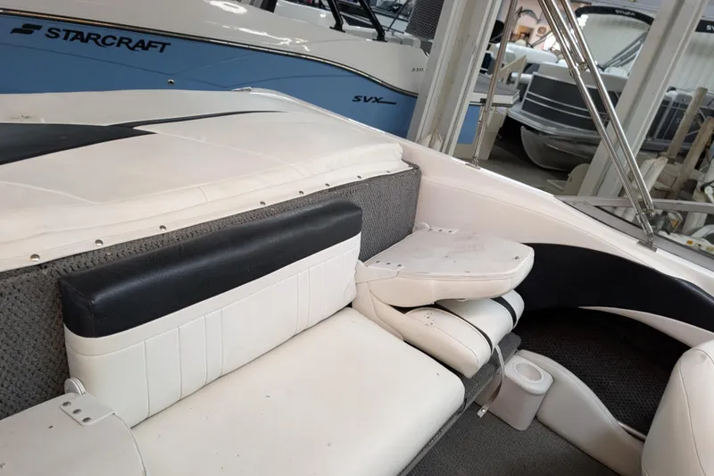 Slide: The Image of 2005 Sylvan V190 I/O boat interior with white and black seating, docked indoors. - 6